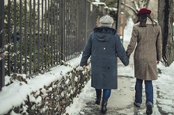 Two women walking on wintery sidewalk