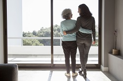 Woman and caregiver standing at window
